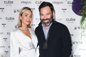 Dr. Nicole Martin in a white dress standing with Anthony Lopez wearing a black sweater.