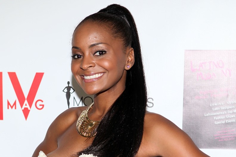 Royce Reed in a white dress and black ponytail, smiling.