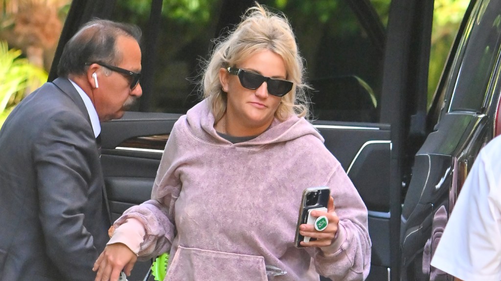 Jamie Lynn Spears in a pink hoodie and sunglasses exiting a vehicle