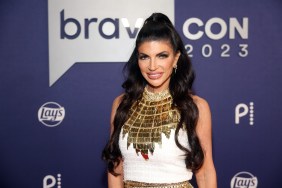 Teresa Giudice smiling and wearing a white and gold dress, standing in front of a BravoCon 2023 sign.