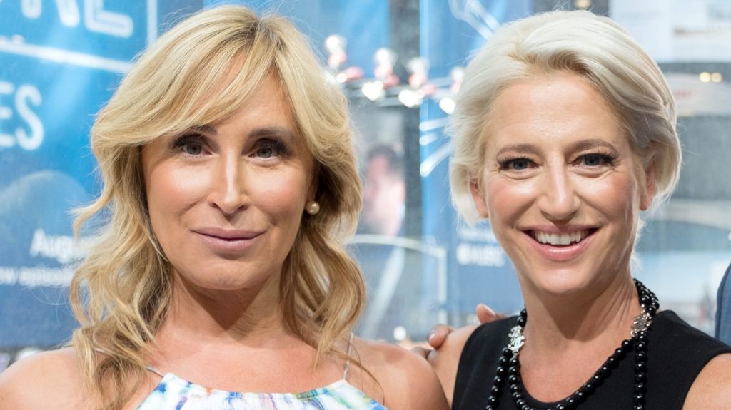 Sonja Morgan in a blue and white floral dress, standing next to Dordina Medley who's smiling and wearing a black dress