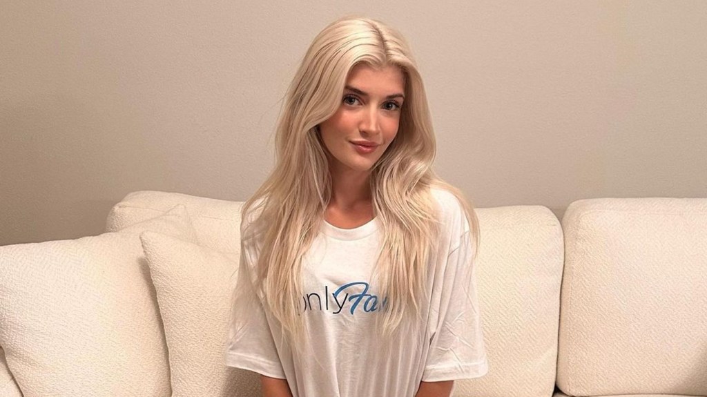 Sami Sheen sitting on a couch wearing a white OnlyFans t-shirt.