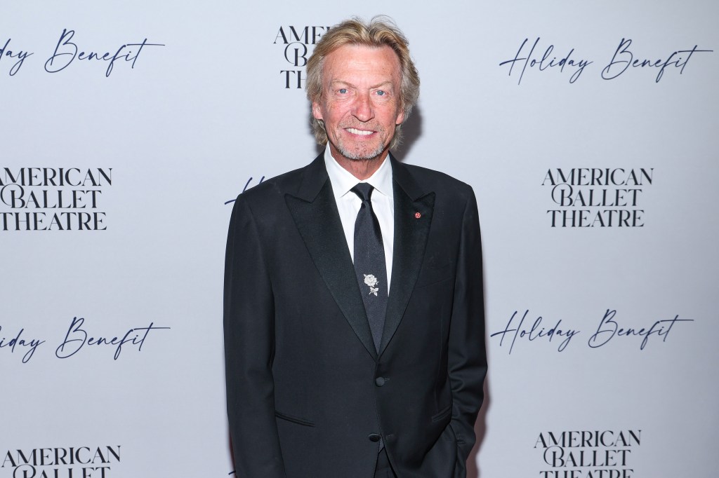 Nigel Lythgoe posing in a black suit.