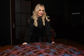 Tamra Judge in a dark cloak standing in front of The Traitors roundtable