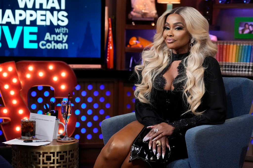 Phaedra Parks on Watch What Happens Live, sitting in a black dress and smirking
