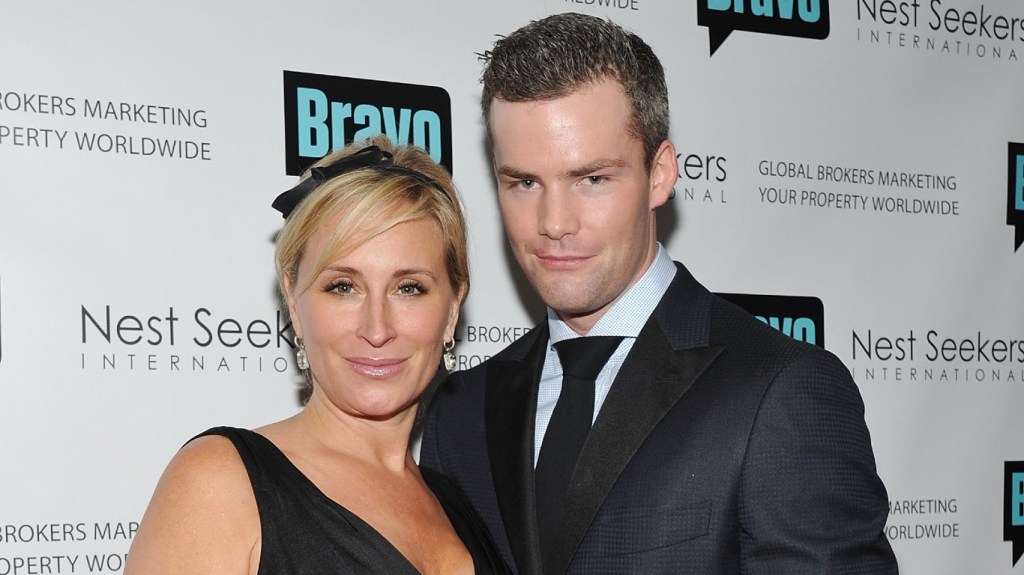Ryan Serhant and Sonja Morgan smiling together and wearing black