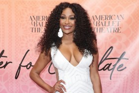 Cynthia Bailey posing in a white dress with her hand on her hip