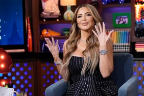 Larsa Pippen in a black dress on Watch What Happens Live, holding both hands up in disbelief