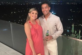 Janet and Jason Caperna standing arm in arm; Janet is wearing a pink dress and Jason is wearing khakis and holding a beer.