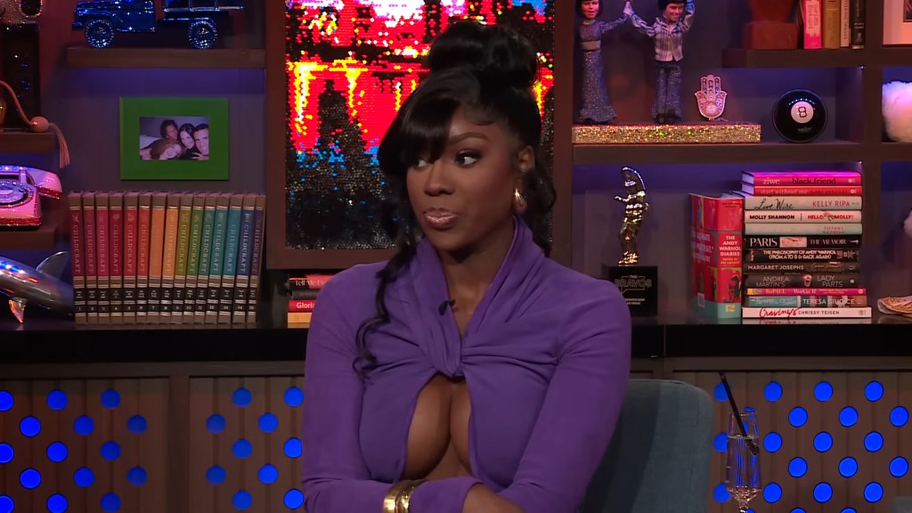 Dr. Wendy Osefo on watch What Happens Live wearing a purple dress and looking to the side