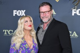 Tori Spelling in a purple dress looking up at her husband, Dean McDermott, who is wearing a black suit