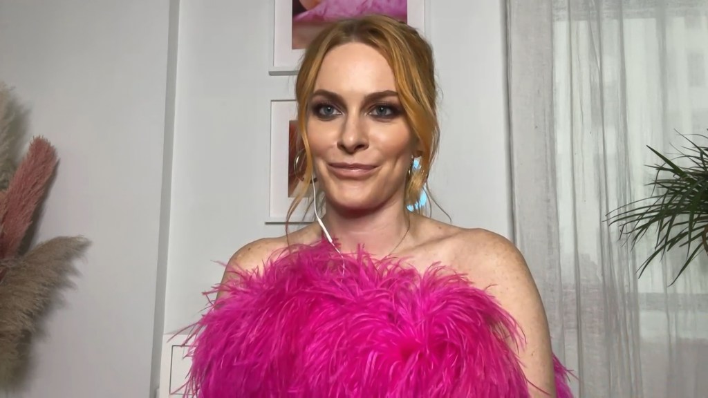 Leah McSweeney smiling and a wearing a pink top with feathers on Watch What Happens Live