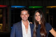 Jesse Lally in a navy blue suit and a white, unbuttoned shirt posing with Michelle Lally who is also wearing navy blue