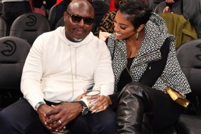 Simon Guobadia in a white sweater sitting with Porsha Williams at a basketball game, she's wearing a black and white jacket