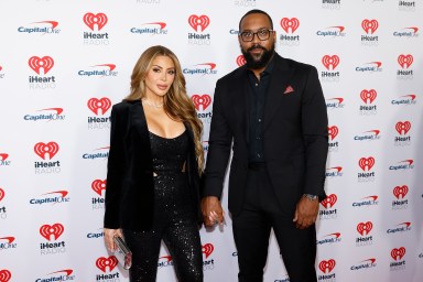 Marcus Jordan and Larsa Pippen wearing all black formalwear and holding hands