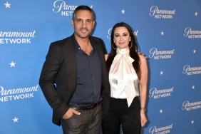 Kyle Richards in a white blouse posing with Mauricio Umanksy in a black suit; they're embracing and smiling