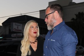 Tori Spelling in a black dress looking up at Dean McDermott, who is looking away from the camera and wearing a blue shirt