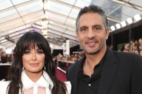 Kyle Richards with bangs in a white suit posing with Mauricio Umansky who is wearing a black suit