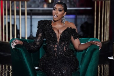 Porsha Williams in a black dress making a shocked expression while sitting on a green chair during the Real Housewives of Atlanta Season 13 reunion