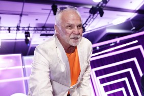 Captain Lee Rosbach at BravoCon wearing an orange shirt and a white blazer; he's leaning over towards the camera and squinting
