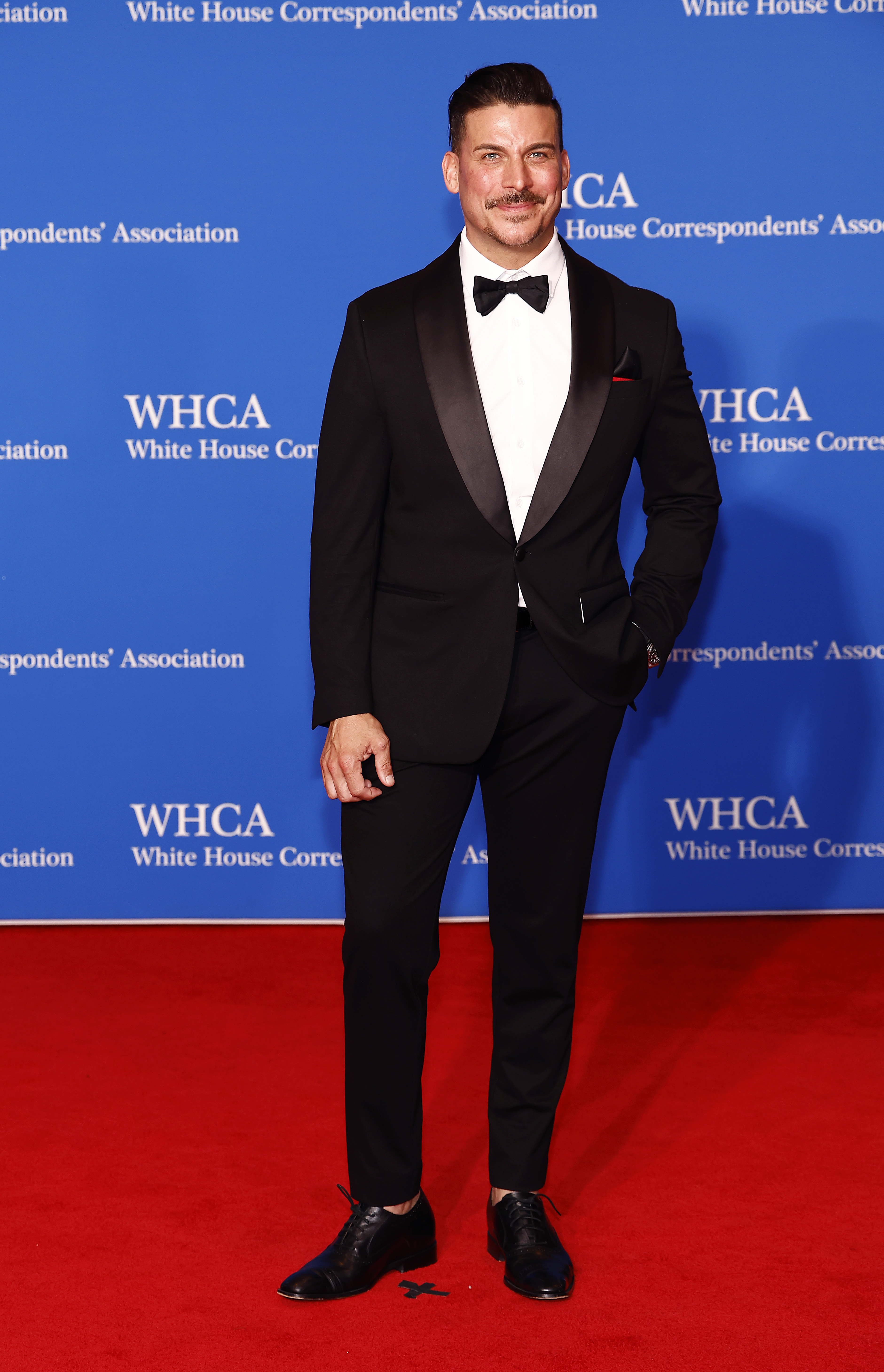 Jax Taylor in a black suit posing on the red carpet at the White House Correspondents Dinner 