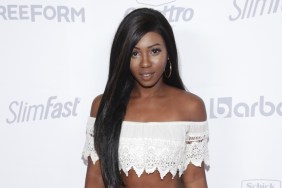 Faith Stowers posing in front of a white backdrop while wearing a white crop top