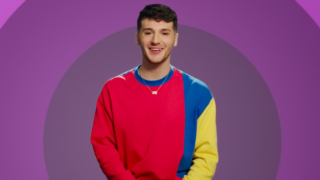 The Circle. Contestant Jordan Staff from episode 606 of The Circle, he's wearing a red, yellow, and blue shirt in front of a purple backdrsop