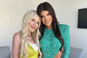 Tori Spelling in a yellow top posing with Teresa Giudice, who is wearing blue