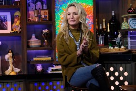 Kate Chastain wearing jeans and a green sweater, sitting with her legs crossed on Watch What Happens Live