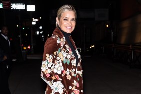 Yolanda Hadid posing in a brown coat with floral designs