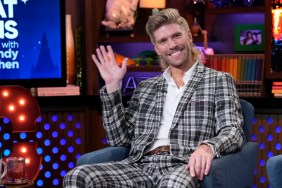 Kyle Cooke in a plaid suit on Watch What Happens Live, he's smiling and waving