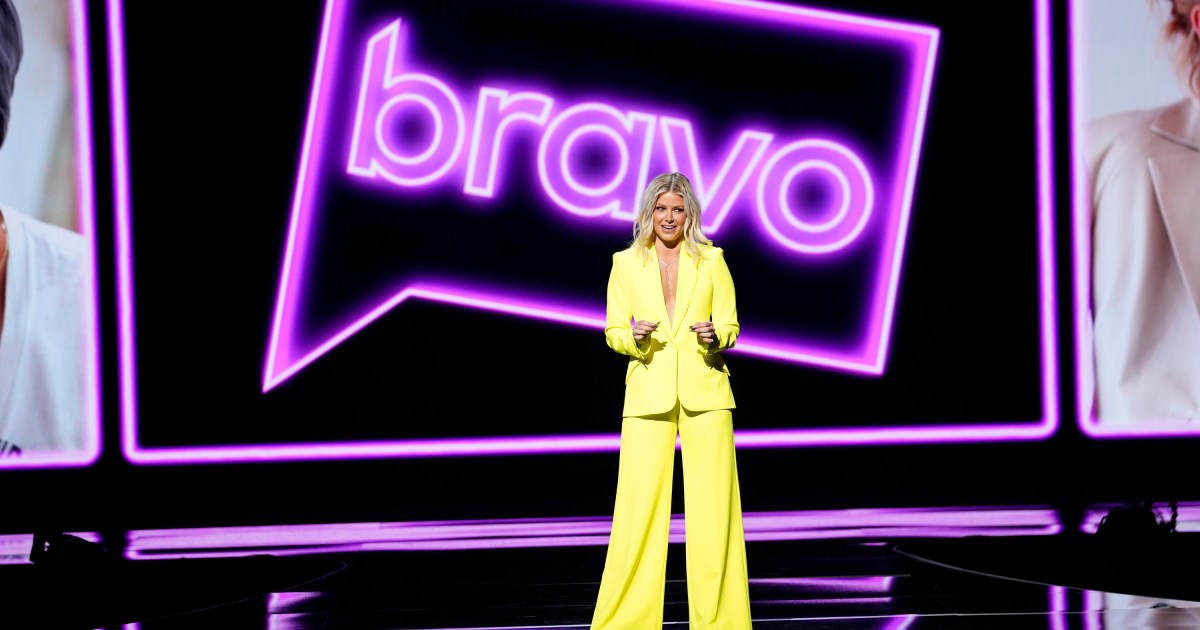 Ariana Madix in a yellow suit standing in front of a purple Bravo logo at the NBC Upfronts 2023