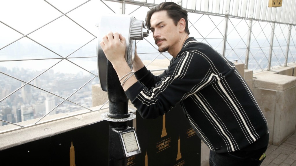 Tom Sandoval looking through a pair of binoculars on top of the Empire State Building