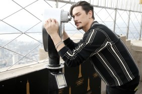 Tom Sandoval looking through a pair of binoculars on top of the Empire State Building