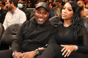 Porsha Williams and Simon Guobadia wearing black and sitting together at a basketball game