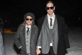 Jenna Lyons and Cass Bird walking in sunglasses and grey suits while holding hands