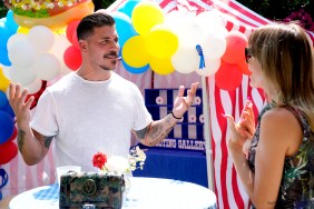 Jax Taylor on The Valley standing at an ourdoor carnival with his hands in the air