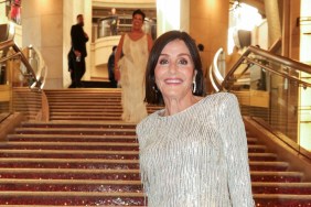 Kathy Swarts posing in a silver dress on a red staircase