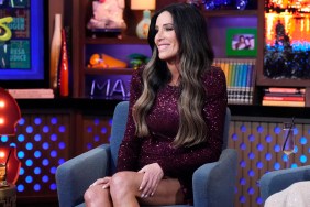 Patti Stanger in a purple dress, smiling, and sitting on stage at Watch What Happens Live