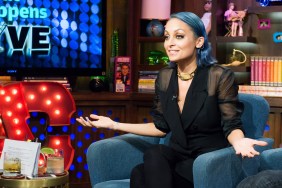 Nicole Richie in a black outfit with blue hair, she's on Watch What Happens Live holding her arms out gesturing in disbelief
