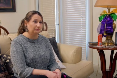 Gypsy Rose Blanchard sitting on a couch in a grey sweater making a contemplative expression