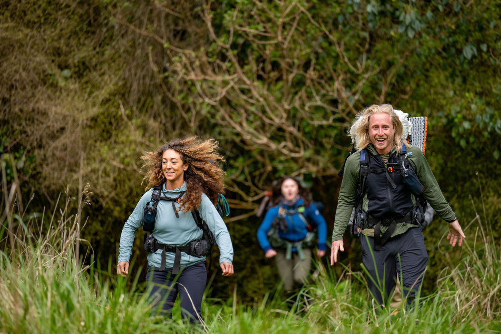 Paulina Pena and Creighton Baird moving through a field on Race to Survive: New Zealand 