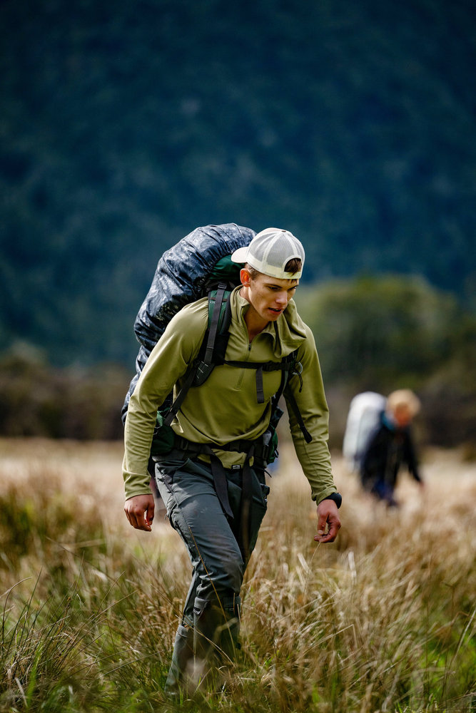 Bronsen Iverson walking through a field on Race to Survive: New Zealand