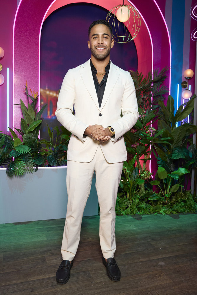Kendall Washington posing in a white suit at the Love Island USA Season 6 reunion