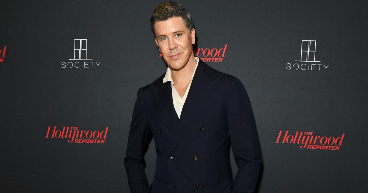 Fredrik Eklund in a black suit posing in front of a black backdrop
