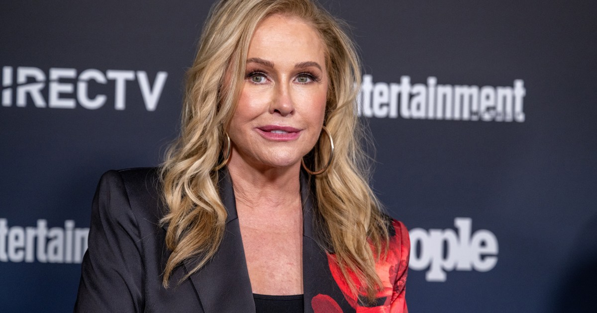 Kathy Hilton in a black suit with a red bow