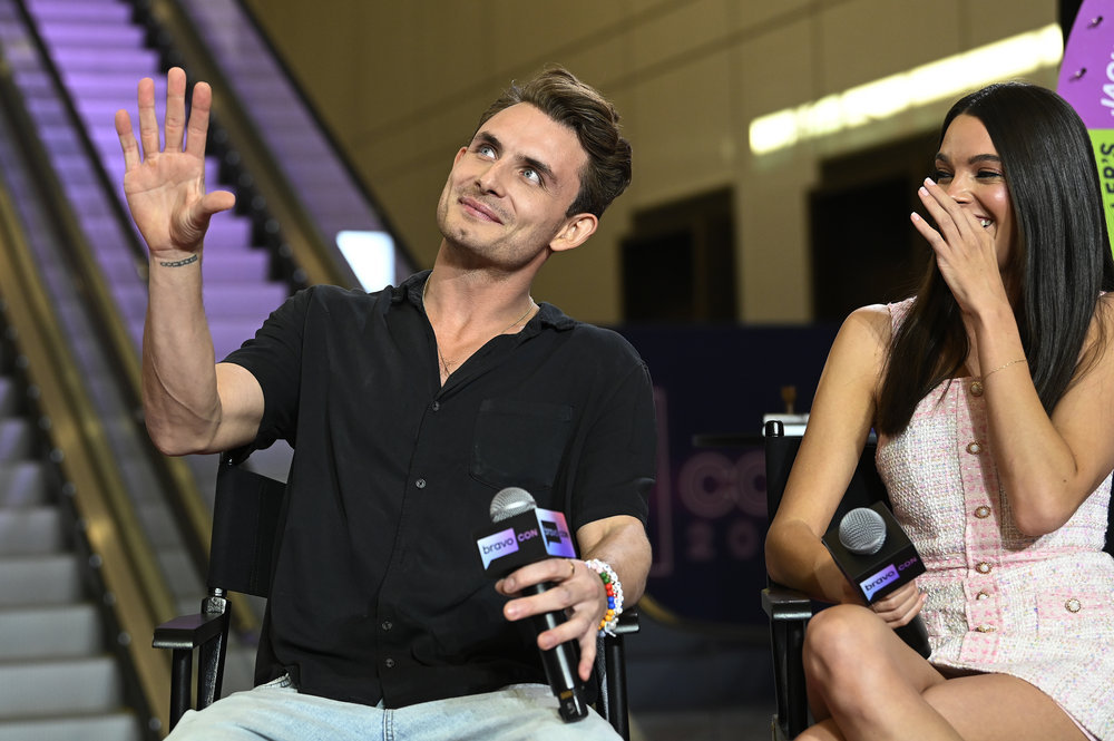 James Kennedy waving and sitting next to Ally Lewber at BravoCon 2023 