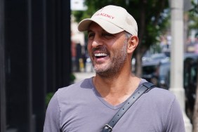 Mauricio Umansky in a grey shirt and white hat, walking down the street smiling