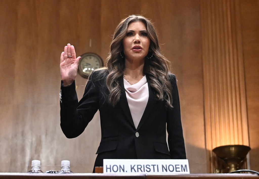 Kristi Noem raising her hand at a Senate hearing