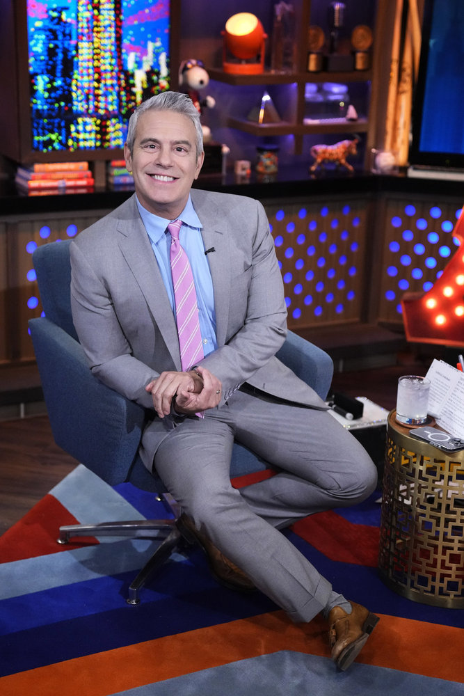 Andy Cohen in a grey suit sitting in his chair on Watch What Happens Live